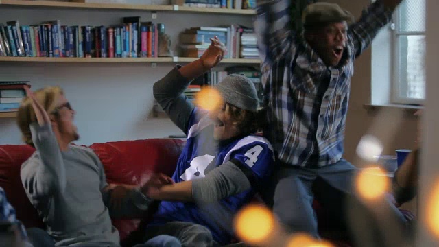 一群年轻的成年男子在一起庆祝看电视上的体育节目视频下载