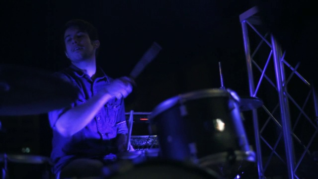 年轻的成年男性鼓手在摇滚乐队宽镜头视频素材