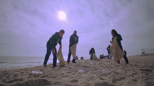 志愿者在海滩上捡垃圾视频素材