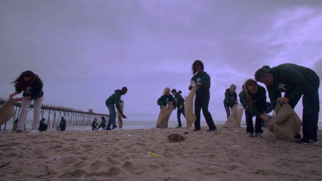 志愿者在码头附近的海滩上捡垃圾视频素材