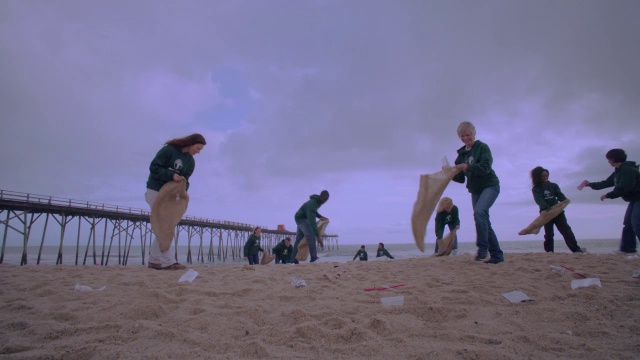 志愿者在码头附近的海滩上捡垃圾视频素材