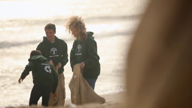 志愿者在海滩上捡垃圾视频素材