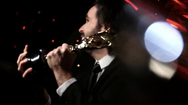 在颁奖典礼上，兴奋的明星拿着奖杯对着镜头微笑视频下载