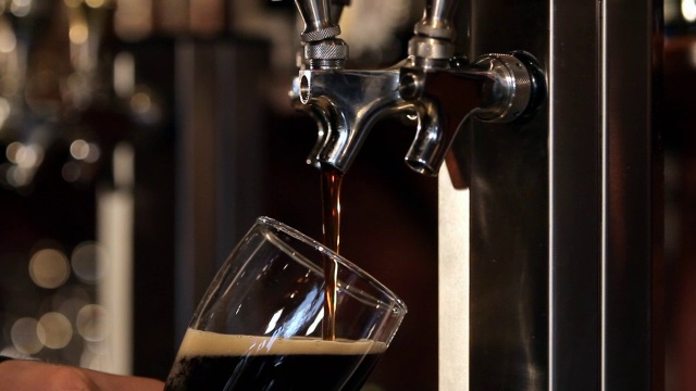 啤酒从龙头倒进玻璃杯。视频素材