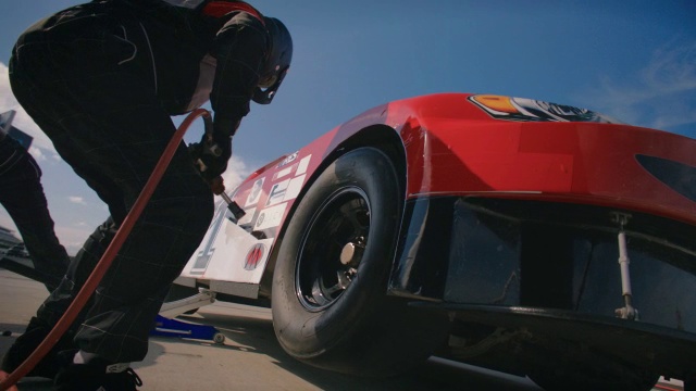 维修站工作人员拧紧新的赛车轮胎耳螺母视频下载