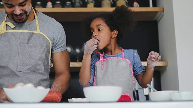 黑人爸爸和小女儿在厨房里一起烘焙视频素材