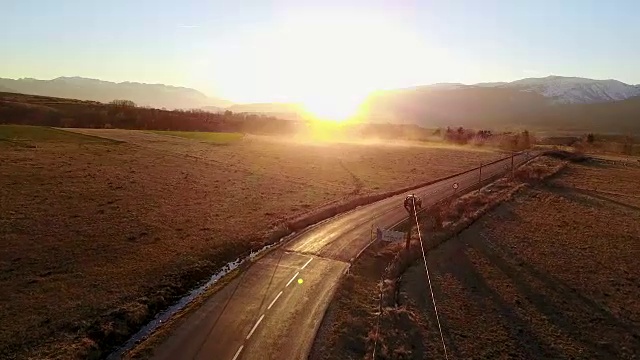在夕阳下行驶在乡间小路上的汽车视频下载