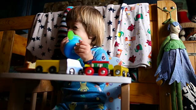 金发小孩喝婴儿奶瓶里的牛奶视频素材