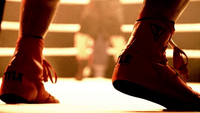 慢动作，中等射击，有选择的焦点，拳击手的靴子在画布上跳在擂台/对手的背景视频下载