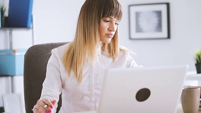 职场女性在办公桌上使用笔记本电脑视频素材