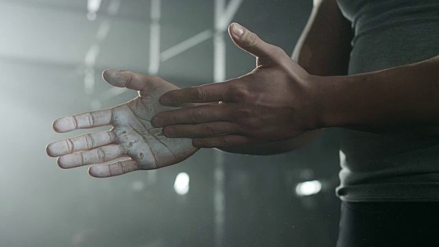 男运动员在体育馆把粉笔放在手上视频素材