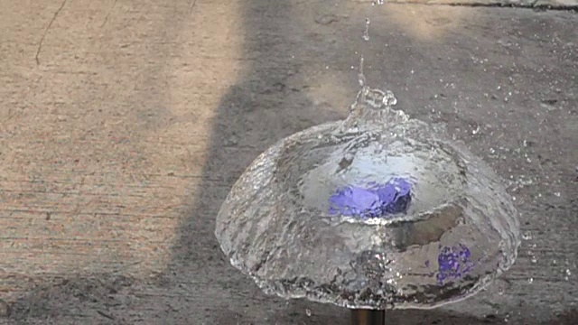 飞镖刺穿紫色水球的慢动作视频素材