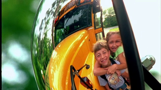 公共汽车的镜子映出一对兄妹拥抱在一起。视频素材