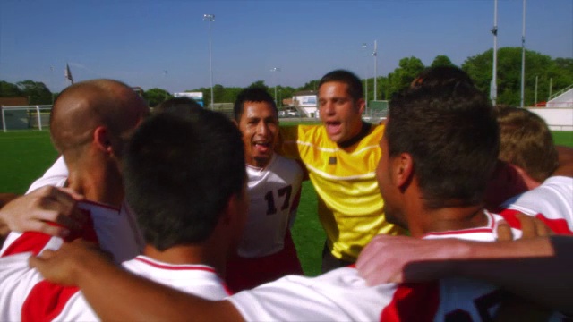 宾夕法尼亚州的一个男子足球队在一个场地上一起跳成一团。视频素材