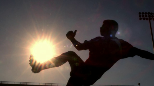 男足球运动员踢高球的宽幅(剪影)视频素材