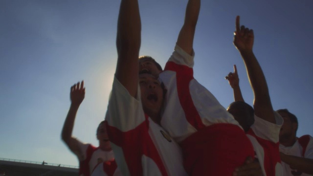 足球队友在空中挥舞拳头以示庆祝。视频素材