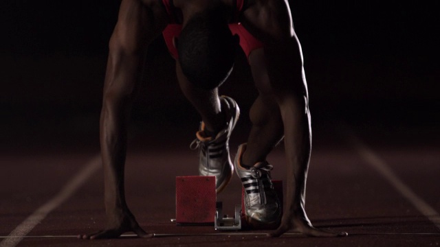赛跑运动员在比赛前，要在起跑点蹲下，伸展身体。视频下载