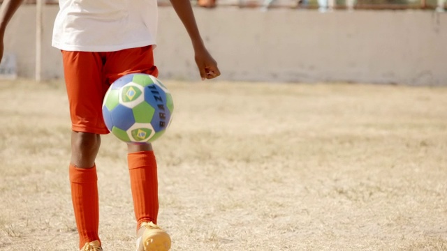 巴西男孩用脚杂耍和拖延足球视频素材