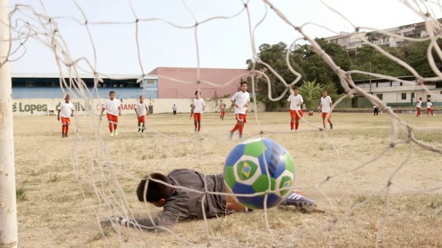 巴西男孩在青少年足球训练中踢点球得分视频素材