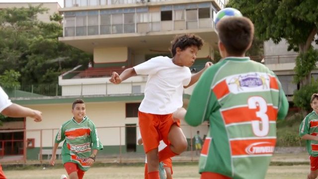 在球队混战中，巴西男孩腾空而起，用慢镜头顶着足球视频素材