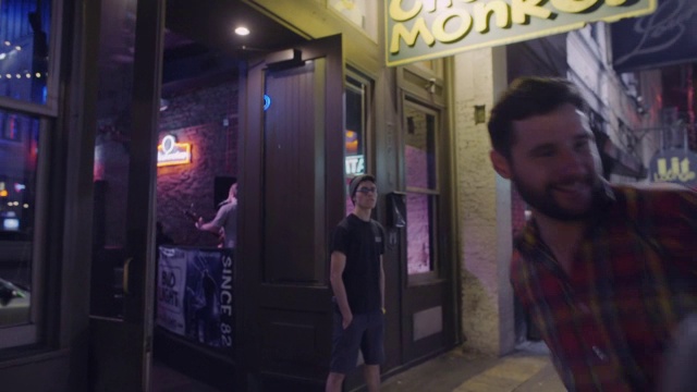 晚上，一群朋友走进德克萨斯州奥斯汀市中心的一家酒吧，和门卫打招呼视频素材