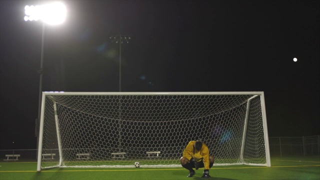 一支足球队在庆祝他们的胜利，而对方的守门员则失望地蹲在地上。视频素材