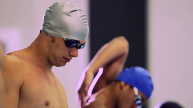 男游泳运动员在比赛前伸展手臂。视频素材