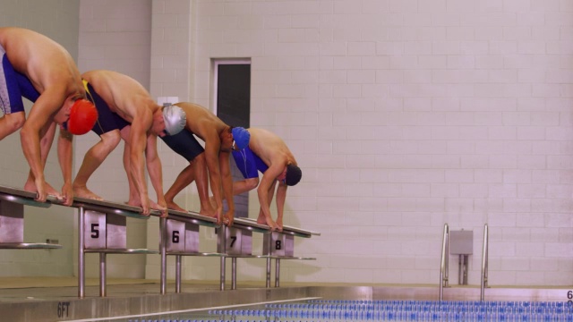 游泳者排成一行从平台上跳下去，开始比赛。视频素材