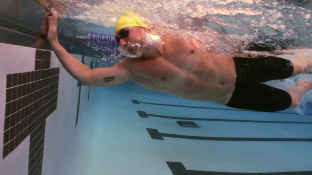 一名游泳运动员在自由泳比赛中获胜，并挥舞拳头以示庆祝。视频素材
