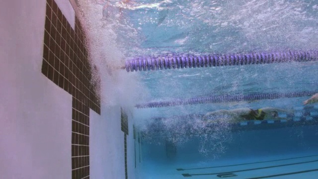 在自由泳比赛中，游泳运动员在泳池边转弯。视频素材