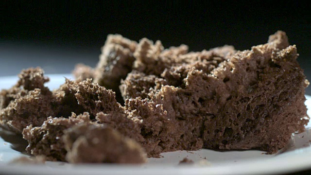 巧克力蛋糕掉到盘子上的慢动作镜头。视频素材