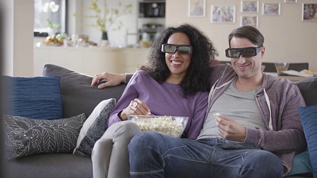 一对夫妇喜欢看3D电视视频素材