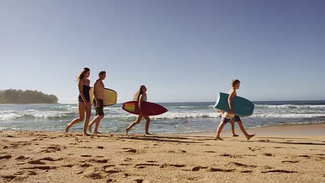 一个白人家庭在海滩上散步视频素材