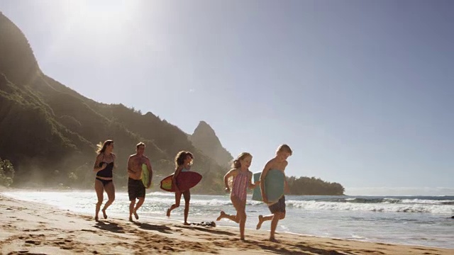 一个白人家庭在海滩上赛跑视频素材