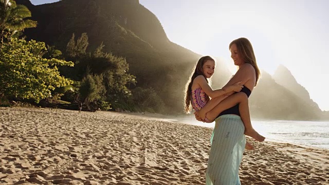 白人母亲抱着小女儿在沙滩上视频素材