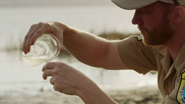 公园管理员收集从湖/葡萄园，美国犹他州的水样本的特写视频下载