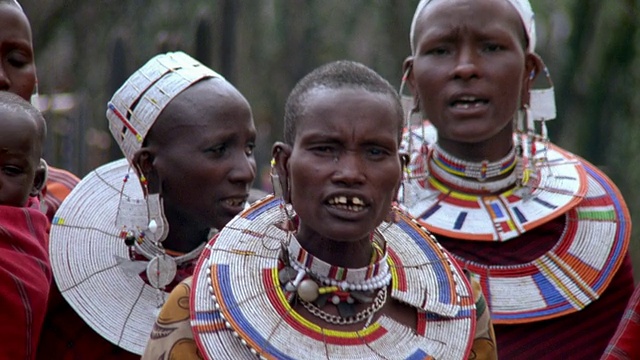 特写镜头:三个穿着部落装饰品的马赛妇女在南非唱歌跳舞视频下载