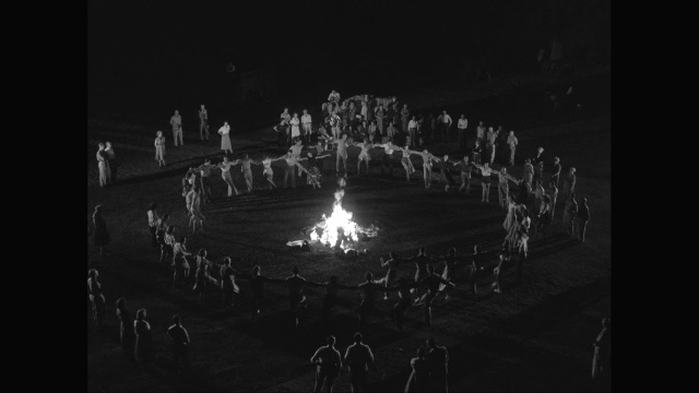 一群手挽着手围着篝火跳舞的人/美国视频下载