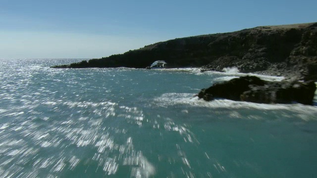 航拍沿毛伊岛崎岖的南海岸飞行与波科瓦伊海拱门的景色。视频素材