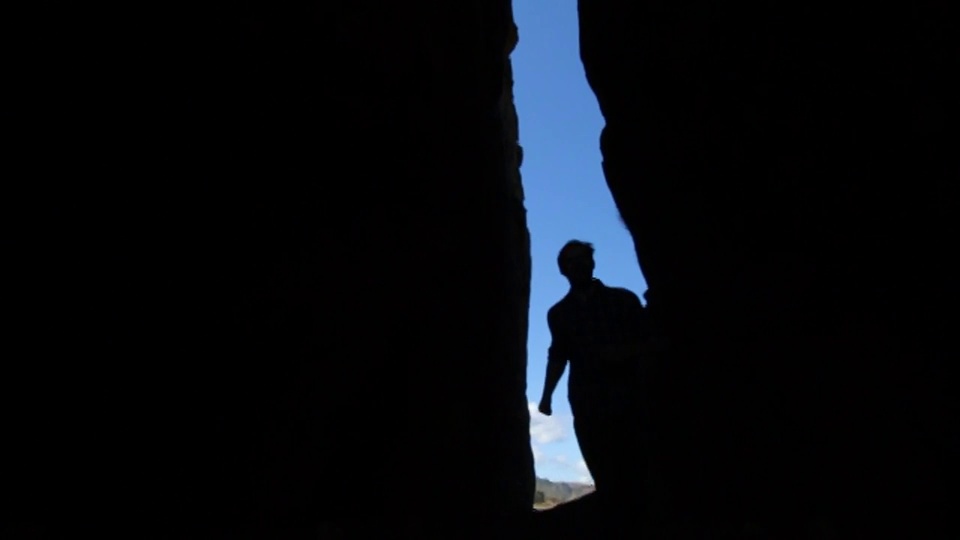在智利海岸，一名男子跑过巨大的岩石裂缝视频下载