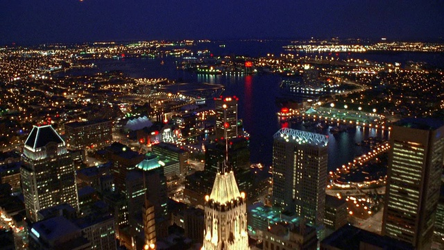 巴尔的摩市中心上空的航拍，在晚上/马里兰州朝向和越过港口视频下载