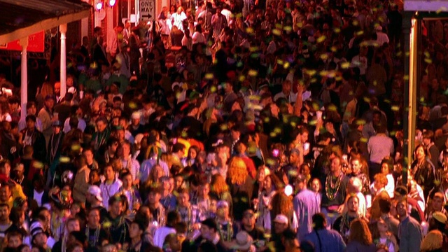 高角广角镜头倾斜，五彩纸屑落在波旁街/新奥尔良庆祝狂欢节的人群中视频下载