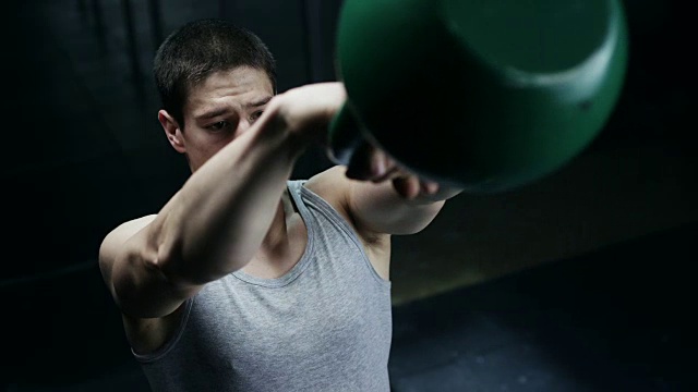专注的男人在健身房用壶铃做运动视频素材