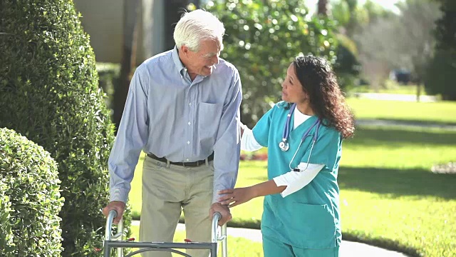 护士帮助老人在户外使用助行器视频素材