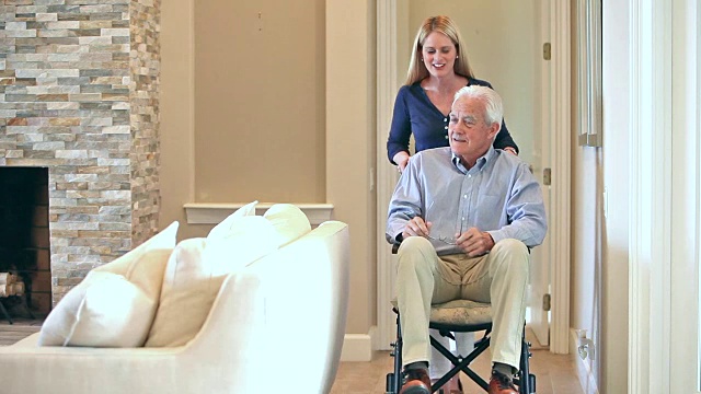 在家里推着轮椅上的老人的女人视频素材