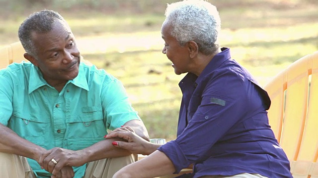 一对非裔美国老年夫妇坐在户外聊天视频素材