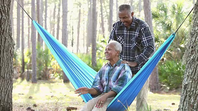 一对老年夫妇在户外，在吊床上荡秋千视频素材