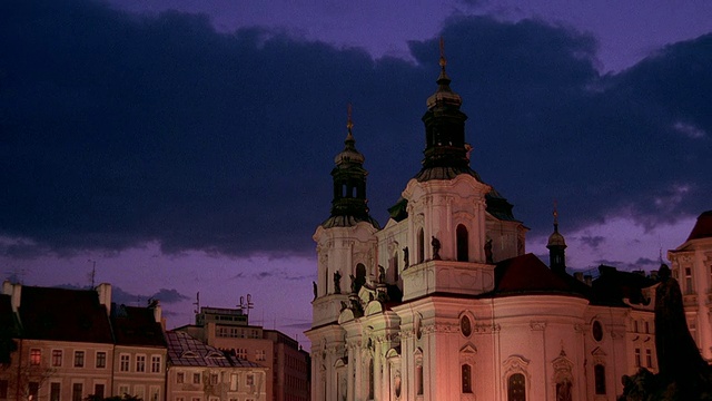 在布拉格老城广场黄昏时，宽镜头延时云在圣尼古拉斯教堂和建筑物上滚动视频下载