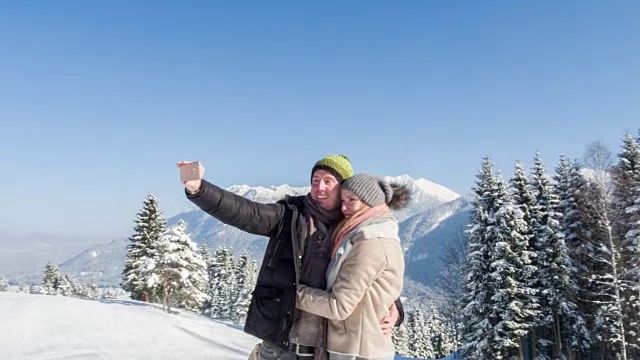 一对年轻夫妇在巴伐利亚阿尔卑斯山的冬季景观中自拍视频素材