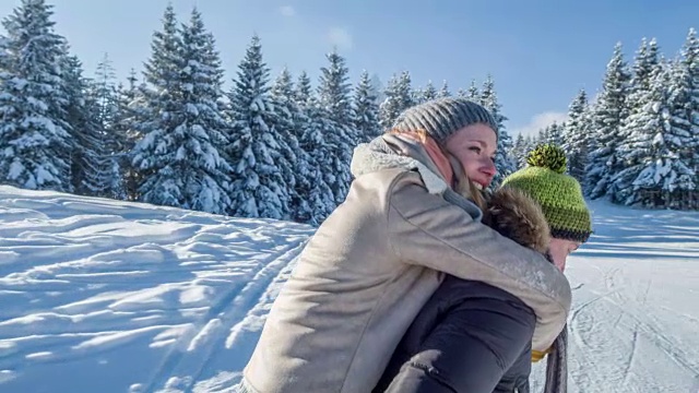 在冬天的景色中，一个年轻人让他的女朋友骑在他的背上视频素材